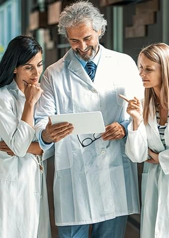 Clinicians in white coats reviewing a chart, stock imagery from The supplier
